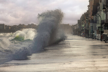 vague qui s'ecrase sur le sillon de saint malo en Bretagne pendant une grande marée - obrazy, fototapety, plakaty
