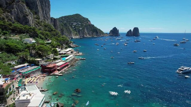 A cinematic aerial shot of the beautiful cliffs and beach landscape of the island of Capri, Amalfi Coast in the Bay of Naples in Italy.