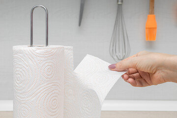 housewife in the kitchen tears off a paper towel, close-up