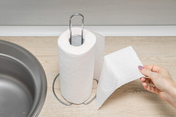 woman's hand tears off a piece of paper towel, close-up