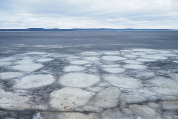 Ice drift in spring on Lake Onega, Karelia. Dangerous thin spring ice in April. Aggregate accumulations of fine-crystalline grains. Opening of small lakes, ponds and reservoirs. Crushed ice floes - obrazy, fototapety, plakaty