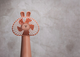 a small pink fan on a beige background. A set of beauty treatment tools