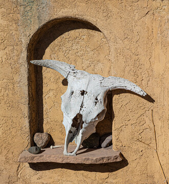 A long bleached-out cow skull resides in an arched stucco niche giving cowboy vibes.