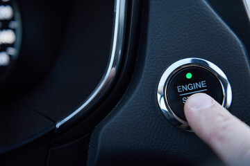 Man presses the engine start button in a car. Starting car engine