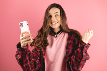 Amazed brunette woman wear red plaid shirt and pink pullover look surprised wow on pink background....
