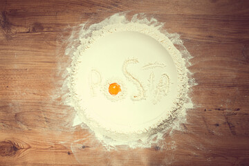 flour on a wooden table, top view, inscription Pasta, with egg yolk, cooking, food concept, no...