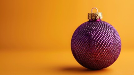 Artistic New Year's bauble with a purple snake skin texture, placed against a minimalist background of warm saffron yellow for a striking contrast