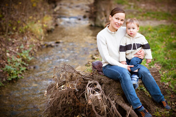 Young mother with son in autumn park