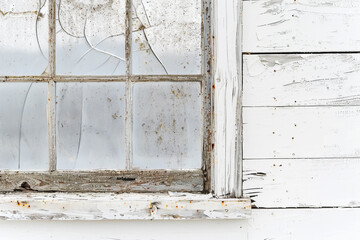A detailed view of an old window, its weathered frame and cracked glass standing out against a pure white background