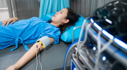 Medical care patient under electronic muscle stimulation with wires attached to the arm and bicep,...