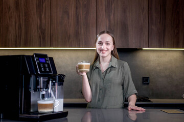 Female enjoying of fresh coffee aroma after brewing coffee using coffee maker in the kitchen at home.