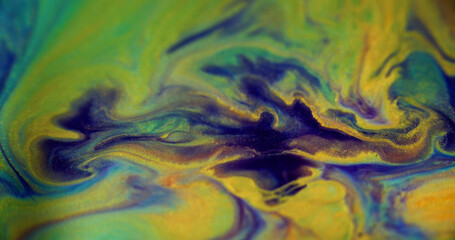 Sparkling ink splash. Liquid glitter. Blur purple blue yellow color shiny golden sand particles...