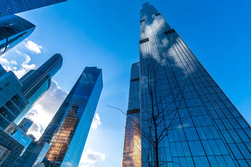 A cluster of tall buildings standing next to each other in a busy urban environment. The...