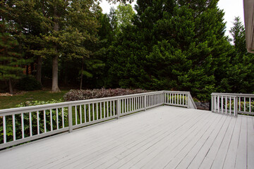 Empty Wooden Grey Deck Overlooks a Peaceful Wooded Backyard