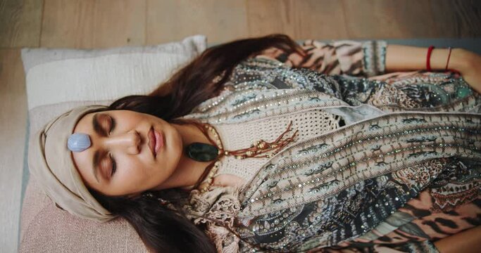 Holistic, healing and woman with stone on body for indigenous meditation and relax with peace from crystal. Spiritual, culture and person with rock from healer on chakra to help detox for wellness