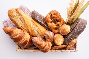 Bakery - various kinds of breadstuff. Rye bread, wholemeal, baguette, sweet bakery products and croissant captured from above (top view, flat lay)