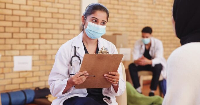 Doctor, patient or health outreach for community service with consultation, healthcare checklist or volunteer. NGO, charity and woman or talking for medical support or social responsibility with mask