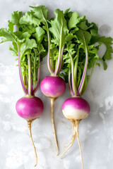 Fresh organic turnips with vibrant purple tops and green leaves.