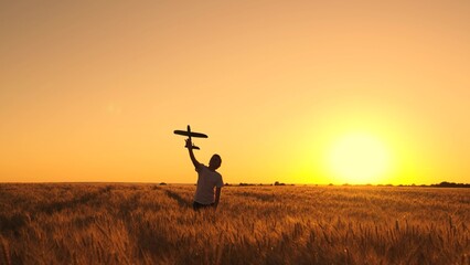 Child play with toy airplane. Teenager dreams of flying, becoming pilot. Happy boy throws toy...