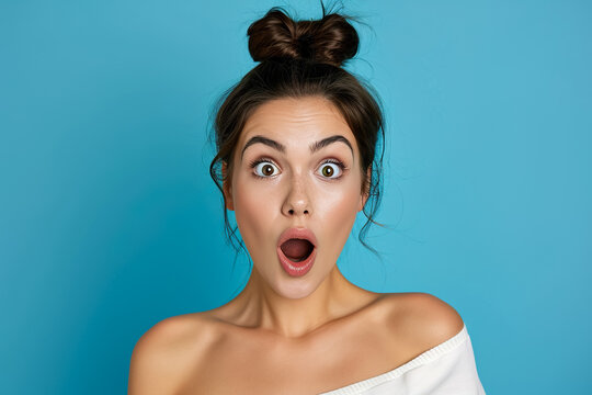 A surprised woman with raised eyebrows on a blue background