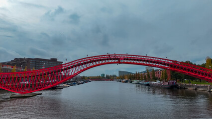 Aerial drone view of modern footbridge Python Bridge at Eastern Docklands neighborhood of Amsterdam...