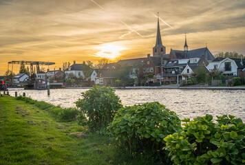 Dutch village of Koudekerk aan den Rijn and Oude Rijn river by sunset