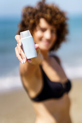 Woman in bikini showing cosmetic product - 784717325