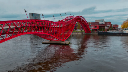 Aerial drone view of modern footbridge Python Bridge at Eastern Docklands neighborhood of Amsterdam...