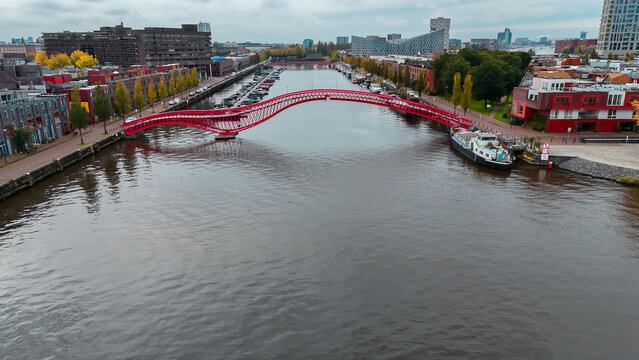Aerial drone view of modern footbridge Python Bridge at Eastern Docklands neighborhood of Amsterdam Netherlands