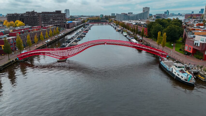 Aerial drone view of modern footbridge Python Bridge at Eastern Docklands neighborhood of Amsterdam...