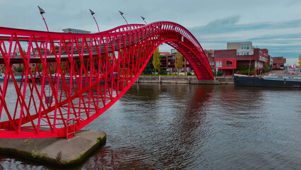 Aerial drone view of modern footbridge Python Bridge at Eastern Docklands neighborhood of Amsterdam...