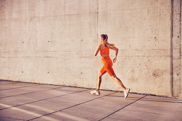 Fit woman running in urban enviroment