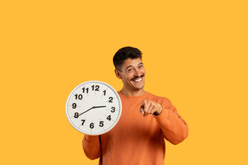 Man pointing at clock with happy expression