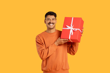 Man presenting red gift box with enthusiasm