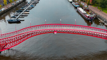 Aerial drone view of modern footbridge Python Bridge at Eastern Docklands neighborhood of Amsterdam...