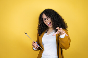 African american business woman with paperwork in hands over yellow background smiling funny doing claw gesture as cat, aggressive and sexy expression