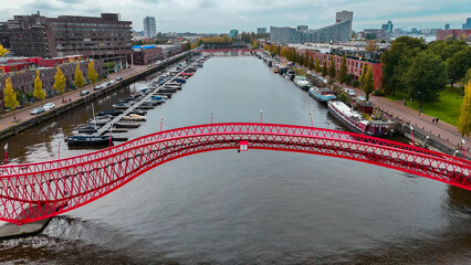 Aerial drone view of modern footbridge Python Bridge at Eastern Docklands neighborhood of Amsterdam...