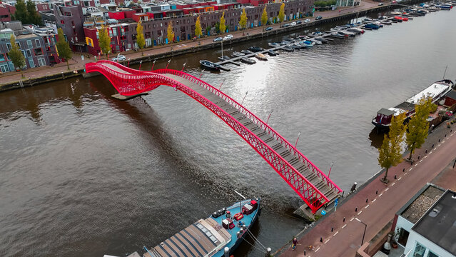 Aerial drone view of modern footbridge Python Bridge at Eastern Docklands neighborhood of Amsterdam Netherlands