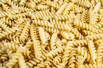 A pile of raw italian fusilli spiral pasta. Texture background.