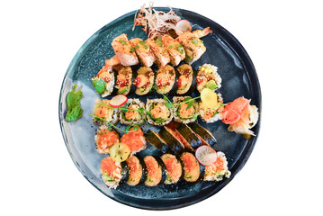 Set of sushi and rolls on a plate with wasabi and ginger, top view.