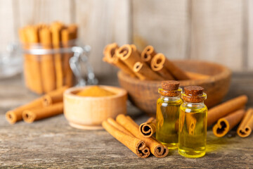 Cinnamon aromatic essential oil and cinnamon sticks on a wooden background. Aromatherapy. Organic cosmetic oil. Spa concept. Place for text. Copy space.