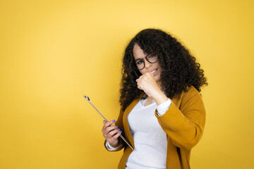 African american business woman with paperwork in hands over yellow background Punching fist to fight, aggressive and angry attack, threat and violence
