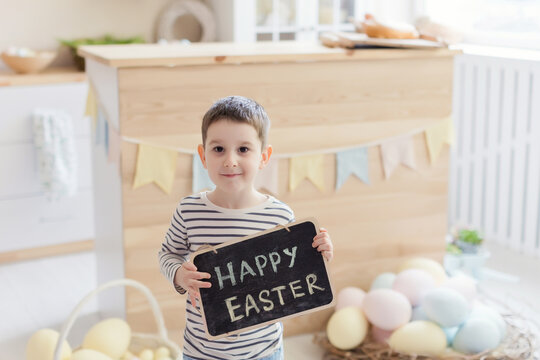 Child holds chalkboard with Easter sign