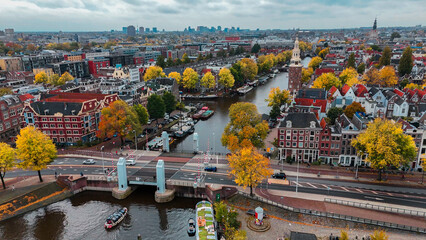Aerial drone view Amsterdam autumn cityscape narrow old houses, canals, boats bird's eye view