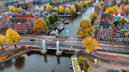 Aerial drone view Amsterdam autumn cityscape narrow old houses, canals, boats bird's eye view