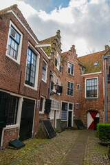 Fototapeta premium The old town of Middelburg, Zeeland, the Netherlands. Kuiperspoort (Coopers gate) in the city of Middelburg is a narrow street with historical warehouses and cobblestones.