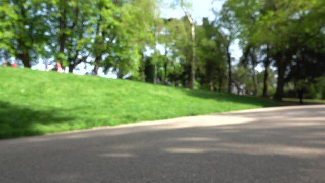 Des joggeurs et promeneurs dans un parc lors d'une belle journée ensoleillée de printemps avec effet flou