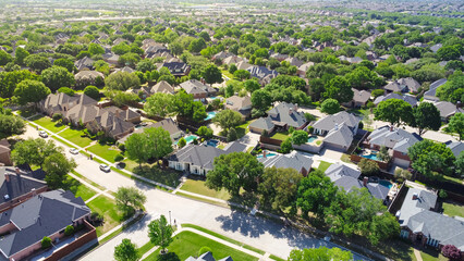 Aerial view lush greenery suburban residential neighborhood subdivision, row of upscale two-story...