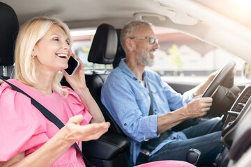 Senior woman on phone call in car, man happily driving
