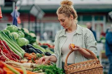 Customer choosing fresh vegetables at farmers market.